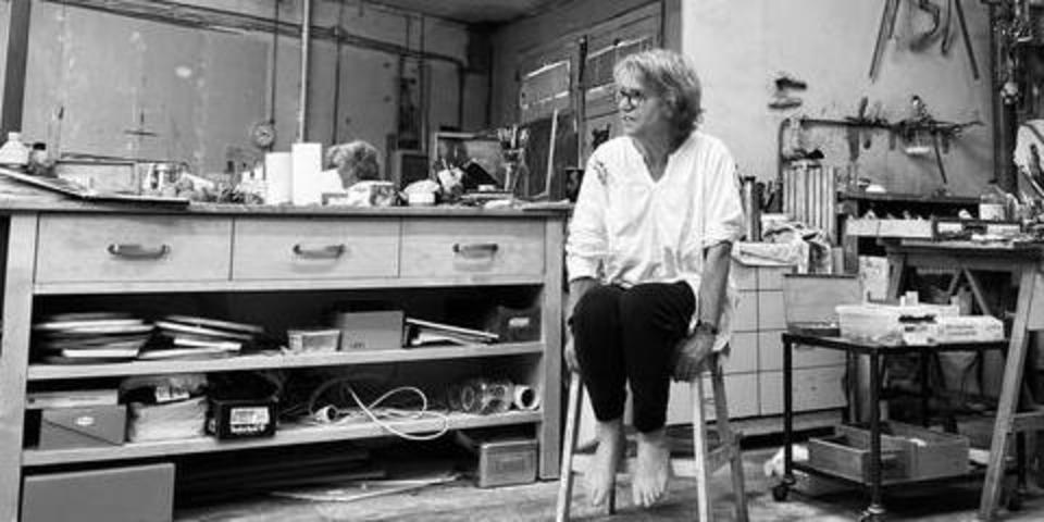 Monique zit op een stoel in haar atelier